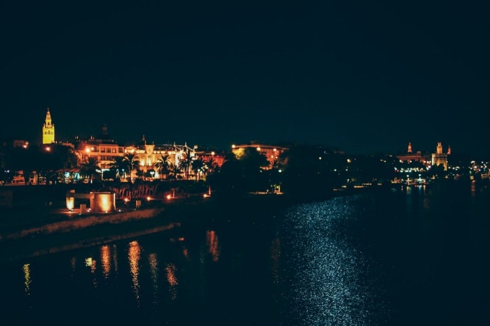 vue de seville la nuit depuis le pont sur la guadalquivir, voyage en espagne